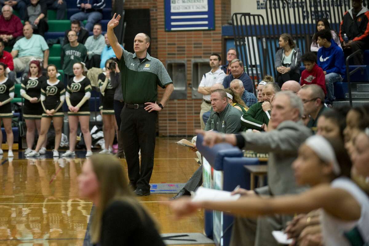 ERIN KIRKLAND | ekirkland@mdn.net Dow head coach Kyle Theisen calls out to his players from the bench during semifinals of the Class A girls' basketball district tournament on Wednesday at Saginaw Heritage High School. The Chargers defeated the Hawks 37-30.