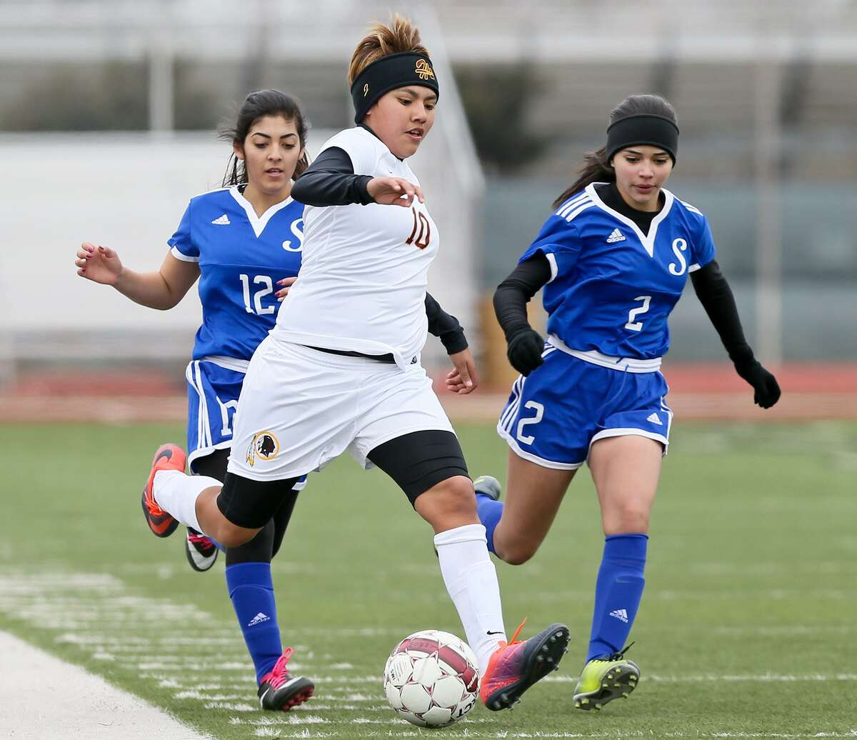 Harlandale's Jazmine Baltazar (center) drives the ball past Somerset's Larissa Galvez (left) and Valeria Munoa during their opening game in the Harlandale ISD Varsity Girls Soccer Showcase Tournament at Harlandale Memorial Stadium on Friday, Jan. 6, 2017. Baltazar scored four goals to lead the Lady Indians past Somerset 9-0. MARVIN PFEIFFER/ mpfeiffer@express-news.net