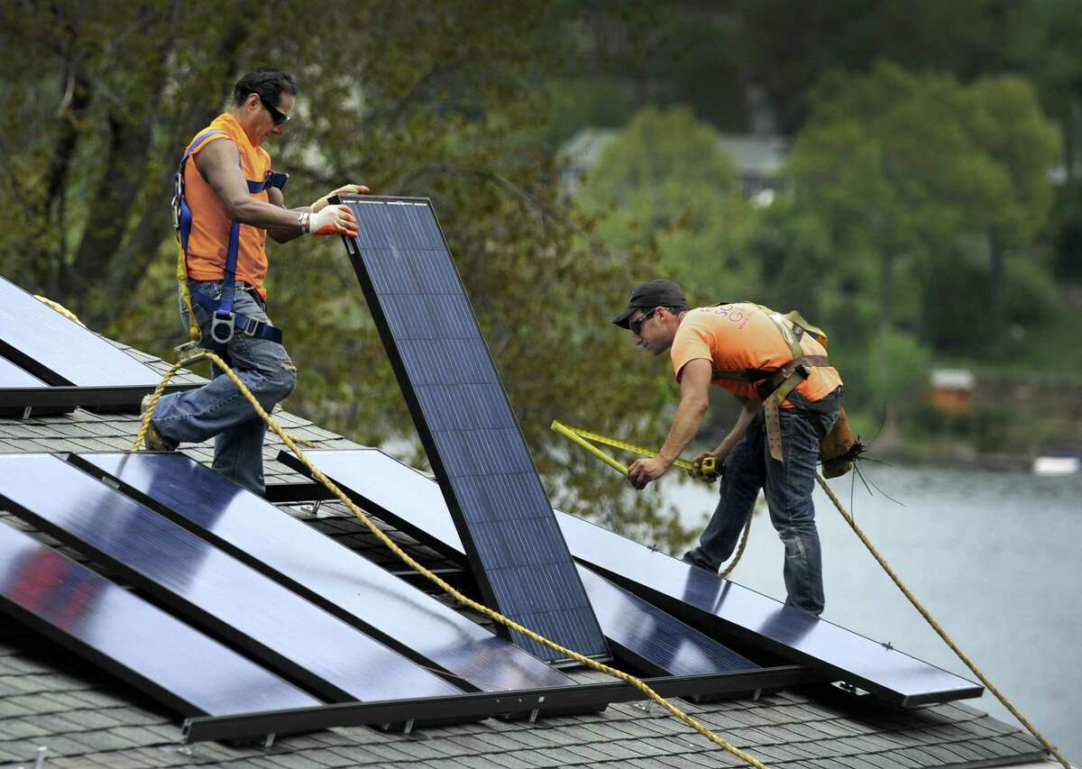 File photo of a crew from Danbury-based Ross Solar Group, LLC installing solar panels on a Brookfield, Conn. home, Tuesday, May 12, 2015.