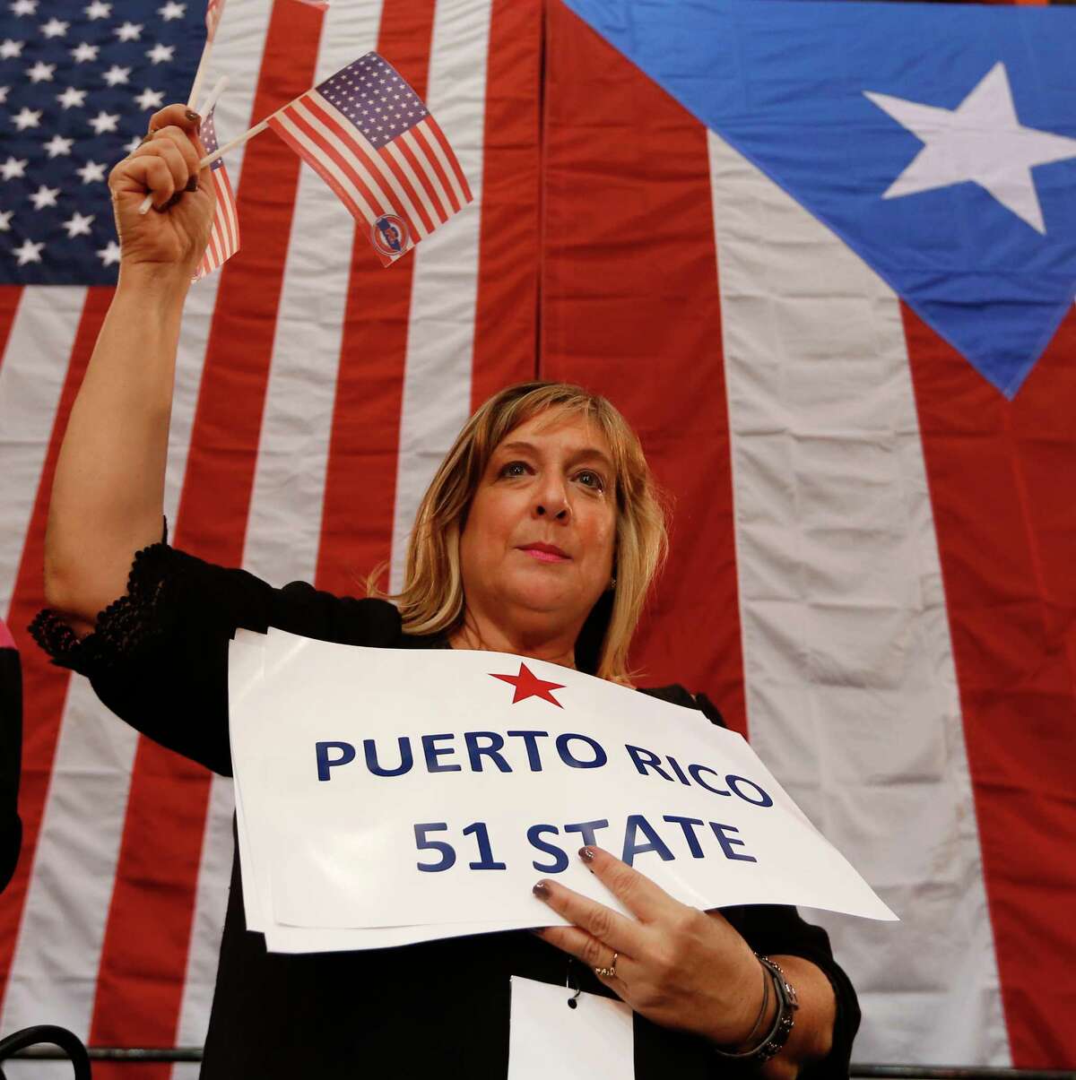 Audience member Arlene Dudeil waves flags during a Republican presidential candidate, Sen. Marco Rubio, R-Fla., rally in Toa Baja, Puerto Rico, Saturday, March 5, 2016.