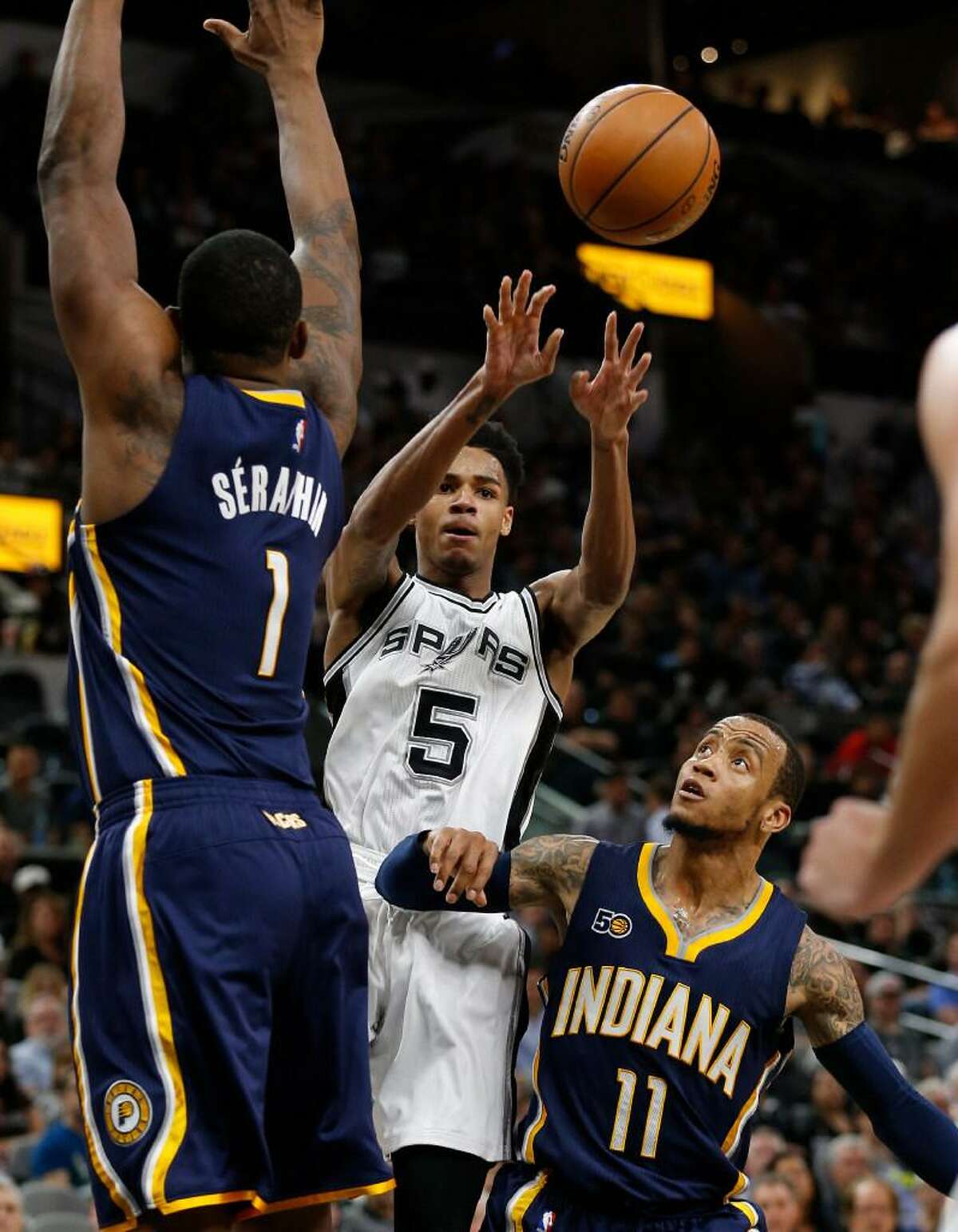 Dejounte Murray makes a pass between Indiana Pacers’ Kevin Seraphin (01) and Monta Ellis (11) during their game at the AT&T Center on Wednesday, Mar. 1, 2017. The Spurs defeated the Pacers, 100-99.