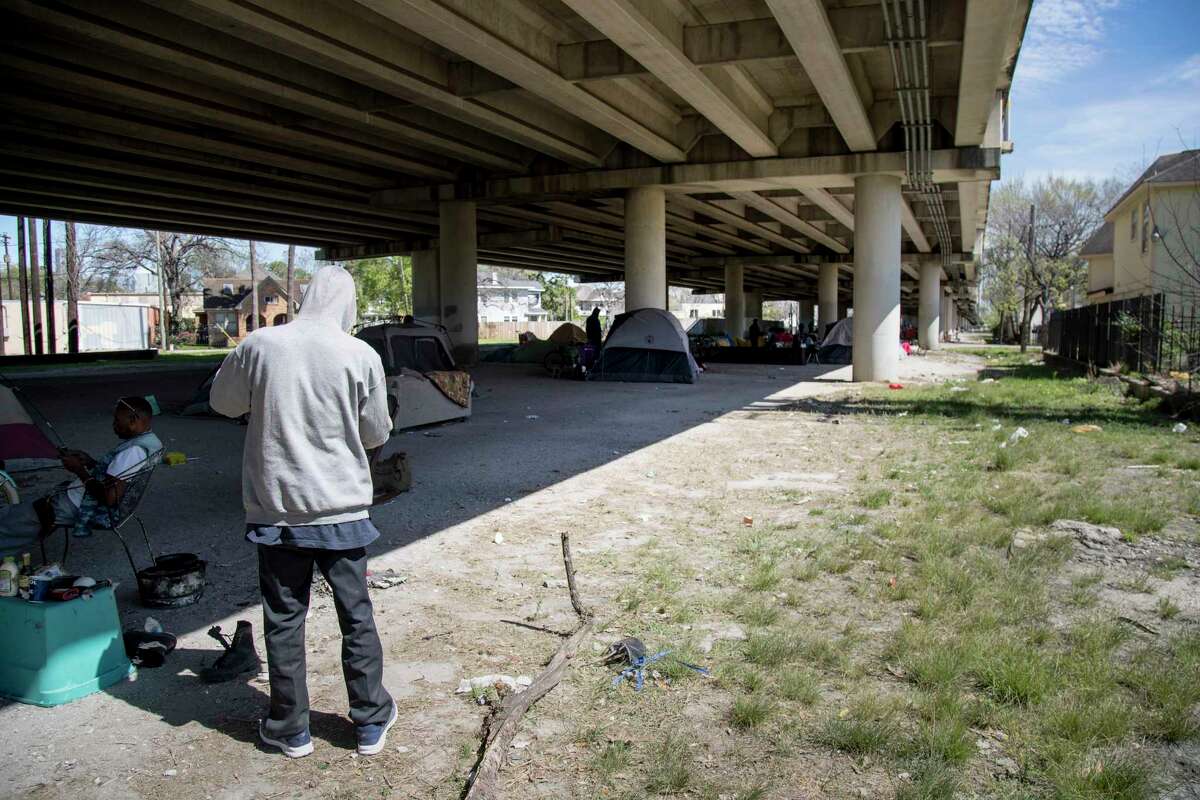 A man who gave his name as, "Mr. Wheeler Station," checks his belongings at his campsite under U.S. 59 near downtown Houston Thursday, March 2, 2017. (Jon Shapley / Houston Chronicle)