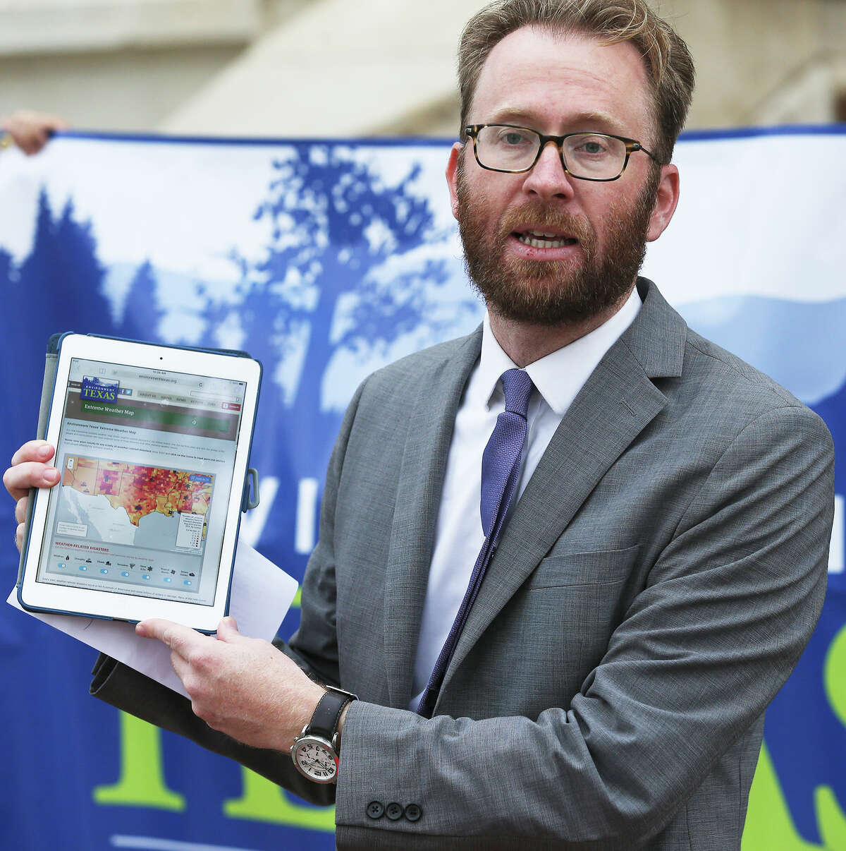 Luke Metzger , Director of Environment Texas shows the online map as his group and Moms Clean Air Force gather outside city hall to give their views on extreme weather and to unveil an interactive weather map on March 9, 2016.