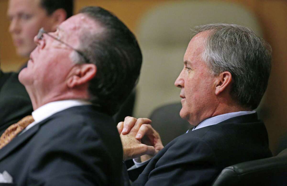 Texas Attorney General Ken Paxton, right, and his attorney Dan Cogdell sit at the defense table during his pretrial hearing ahead of his trial on felony charges that he defrauded investors before taking office, at Collin County Courthouse in McKinney, Texas, Thursday, Feb. 16, 2017. (Jae S. Lee /The Dallas Morning News via AP, Pool)