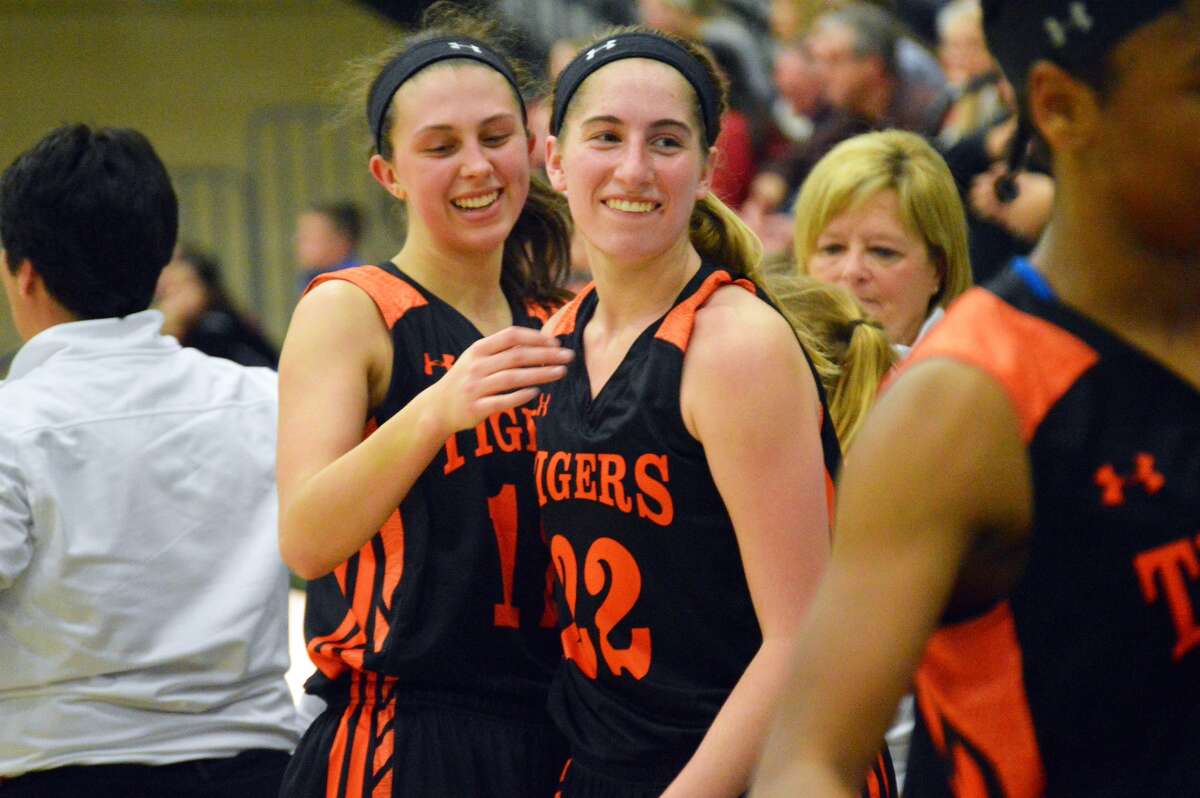 Edwardsville senior Makenzie Silvey, left, and Kate Martin celebrate after coming out of Monday’s super-sectional game with the Tigers comfortably ahead of Lisle Benet Academy.