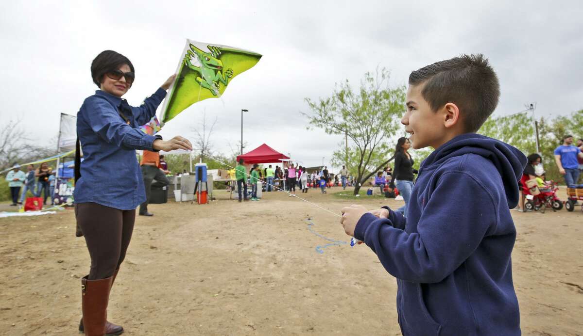 Jose Andres Martinez is assisted by his mother, Bety, as he prepares to launch his kite into the air during the 8th Annual Spring Break Kite Festival at North Central Park.
