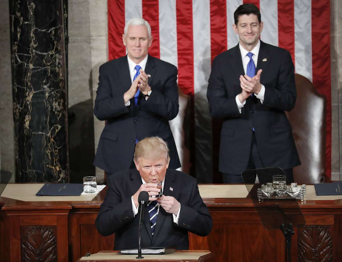 President Donald Trump takes a sip of water from his glass during his address to a joint session of Congress on Capitol Hill in Washington, Tuesday, Feb. 28, 2017. Standing up and applauding in the back are Vice President Mike Pence and House Speaker Paul Ryan of Wis. (AP Photo/Pablo Martinez Monsivais)