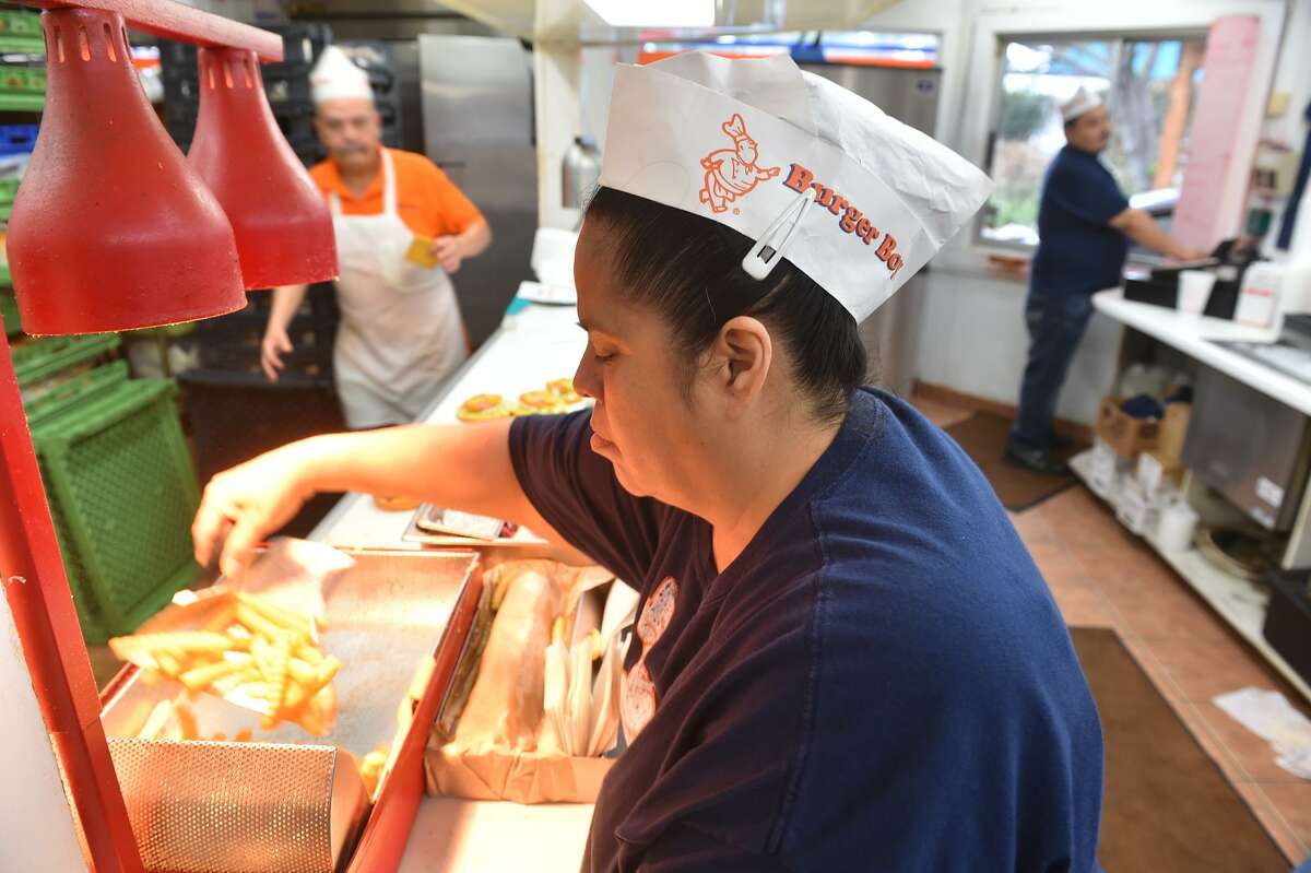 Mary Garcia packages up french fries for customers at the original Burger Boy location at 2323 N. St. Mary's St.