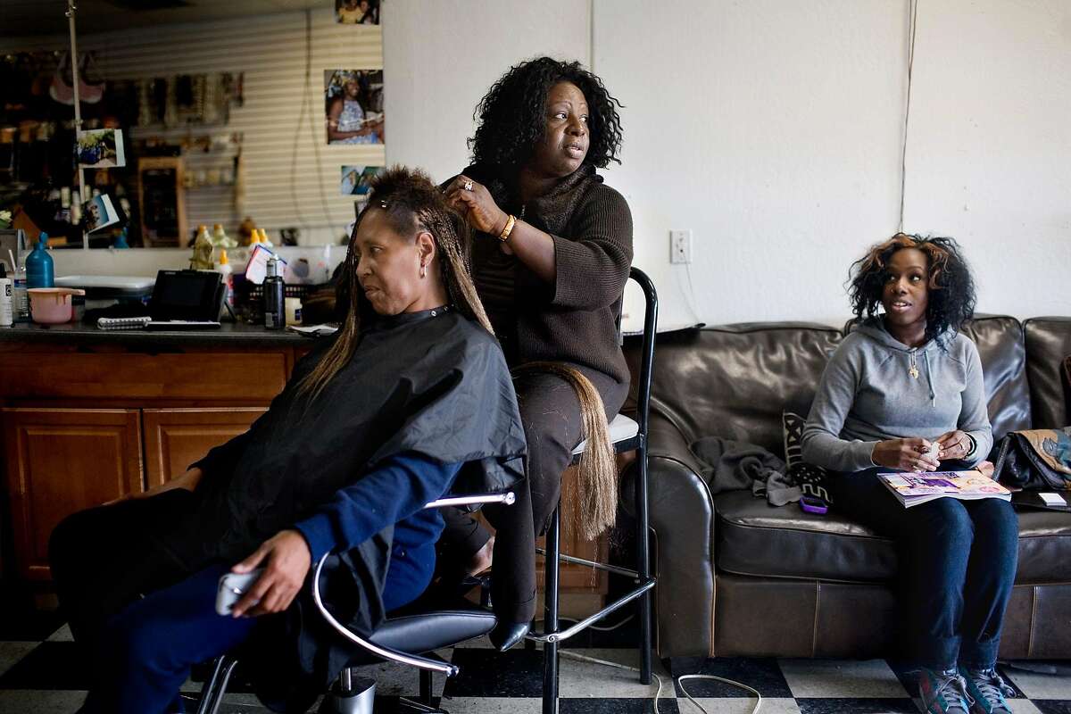 Doris Campbell braids the hair of Annie Davis, in her beauty shop, My African Heritage, in Vallejo.