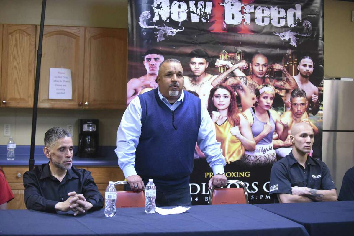 Flanked by boxers Michael Alvarado (left) and Joe Zambrano, Pastor Jimmy Robles of Last Chance Ministries speaks about his church and Scratch Hard Promotions sponsoring a boxing competition Saturday afternoon to raise funds to save the church’s athletic field.