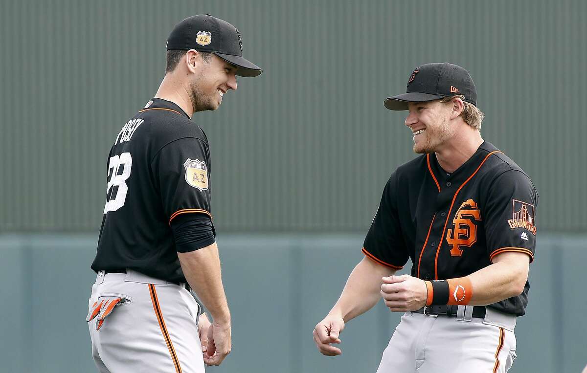 San Francisco Giants catcher Buster Posey, left, jokes around with teammate Gordon Beckham before a Spring Training game against the Oakland Athletics at Hohokam Stadium in Mesa, AZ. on Friday, March 3, 2017. With the hyper-partisan political climate, players are hesitant to talk politics or voice their views in order to keep team unity and chemistry in the clubhouse.