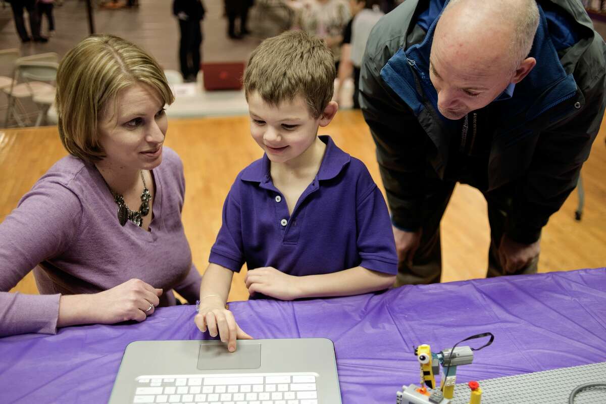 Calvary Baptist robotics coach Jaime Fisk shows first grader Caleb McIntyre, 7, center, and father Scott McIntyre how to control a Lego mouse during an art and academics fair focused on STEM on Friday at Calvary Baptist. The gymnasium was full of art projects, STEM demonstrations, the school's new 3D printer and History Day and science presentations. "You hear about all the schools that are doing STEM, and people look at us and say you're a small school, you can't do that," teacher and registrar Mary Hillebrand said. "I want people to know that we do it, and we do it well." The junior Lego league program, which is for children in kindergarten through third grade, programmed and created animals and their habitats.