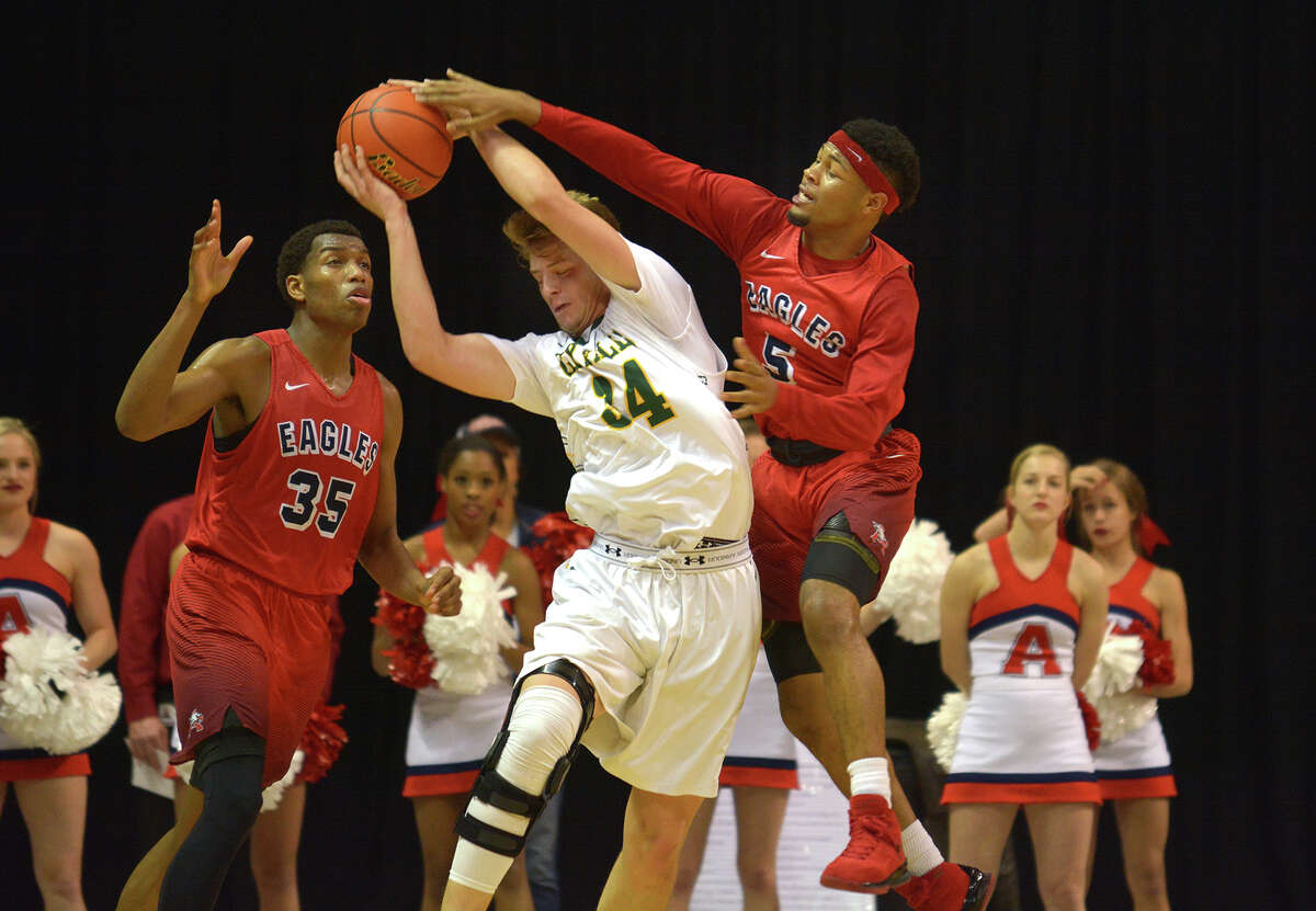 Cy Falls 6'5" senior post controls a rebound between Atascocita senior forward Fabian White (35) and his Eagle teammate and junior guard Devin Harrison (5) during the 4th quarter of their Class 6A Region III Boys Basketball semifinal at the Richard E. Berry Center in Cypress on Friday, March 3, 2017. (Photo by Jerry Baker/Freelance)