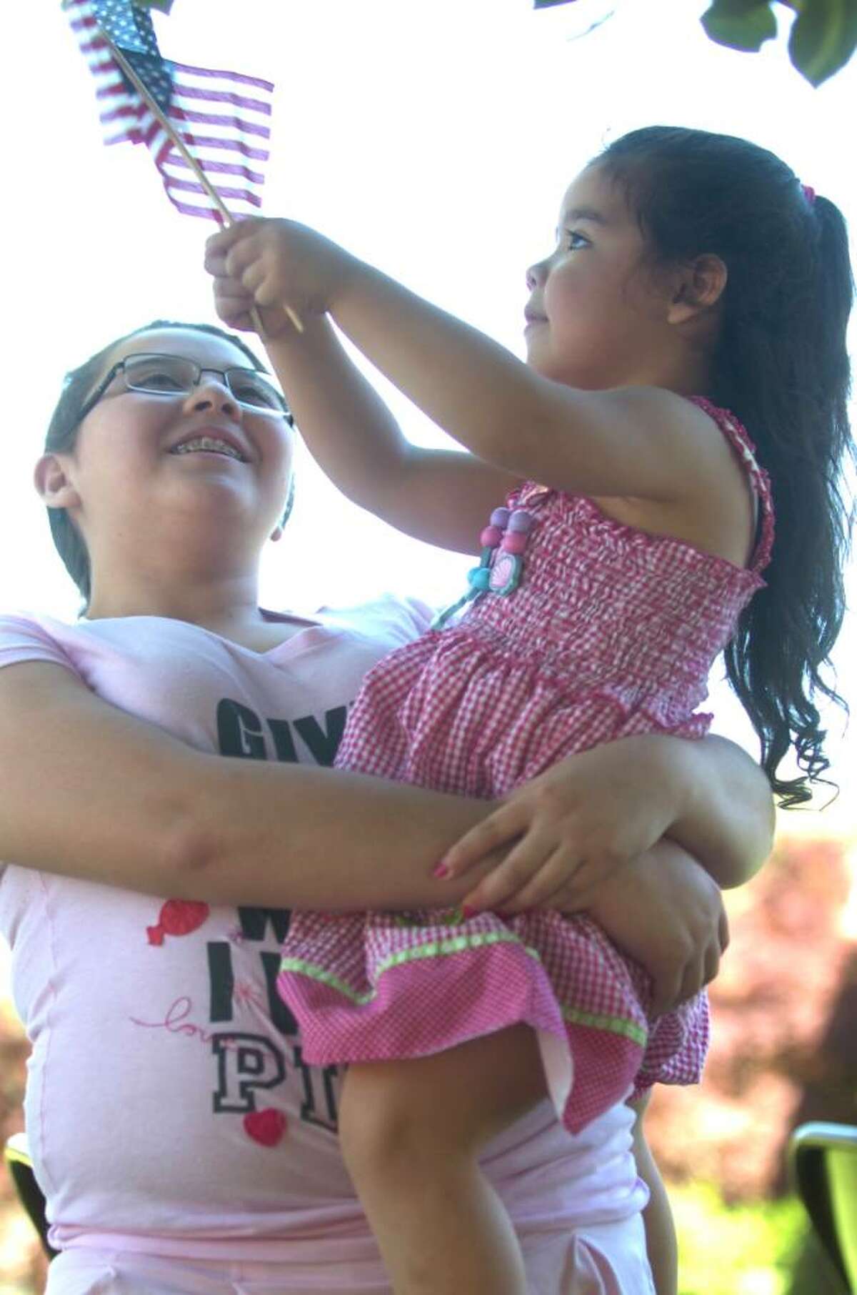 Fernenda Moreno, 12, carries her sister Camila, 3, at the Bryam parade on Sunday, May 30, 2010.