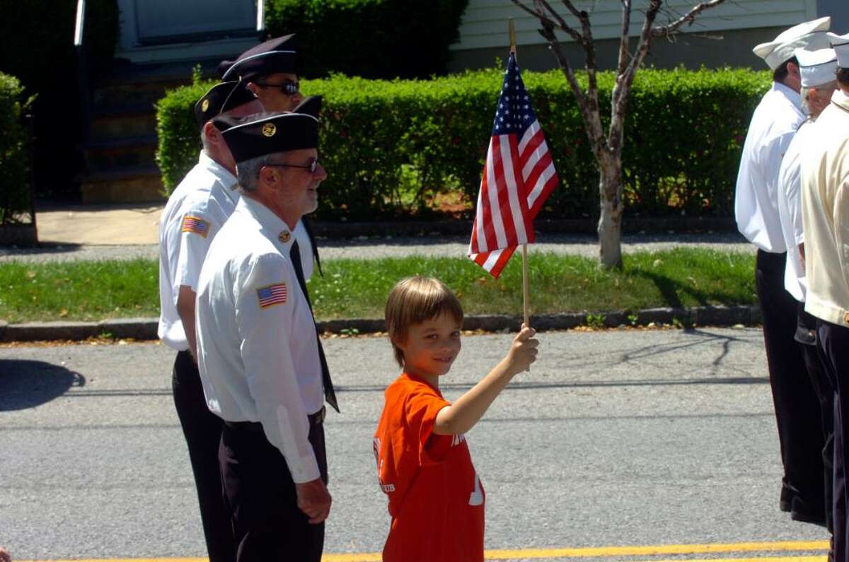 Kevin Wing, 10, waves an American flag while walking with his grandfather Bill Wing, left, at the Byram Memorial Day parade on Sunday, May 30, 2010.