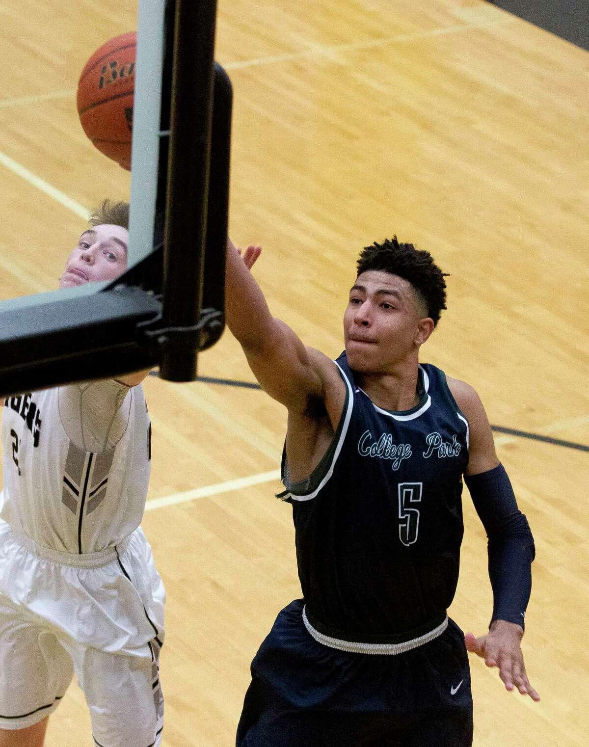 College Park guard Quentin Grimes (5) makes a shot off the backboard as Conroe guard Blaine Alger (22) defends during the fourth quarter of a District 12-6A high school boys basketball game at Conroe High School Friday, Jan. 27, 2017, in Conroe. Conroe defeated College Park 82-65.