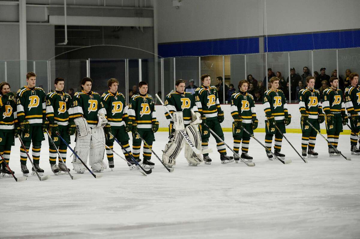 The Chargers stand on the ice during player introductions before their game against Hartland on Saturday at the Midland Civic Arena. Hartland won the game 5-0.