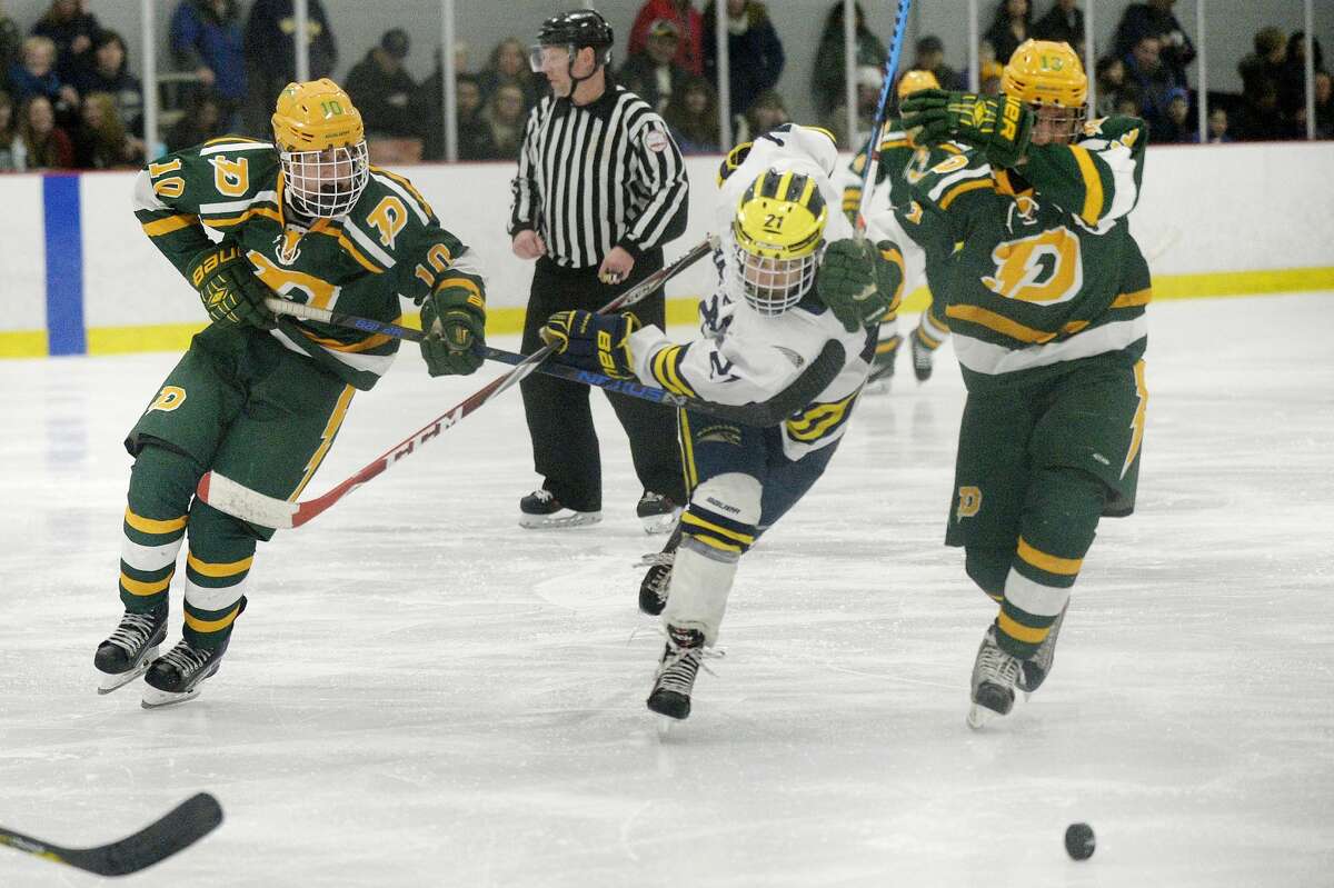 Dow's Jeremy Brookens, left, and Casey LaRue, right, move past Hartland's Lars Storm during the second period on Saturday at the Midland Civic Arena. Hartland won the game 5-0.