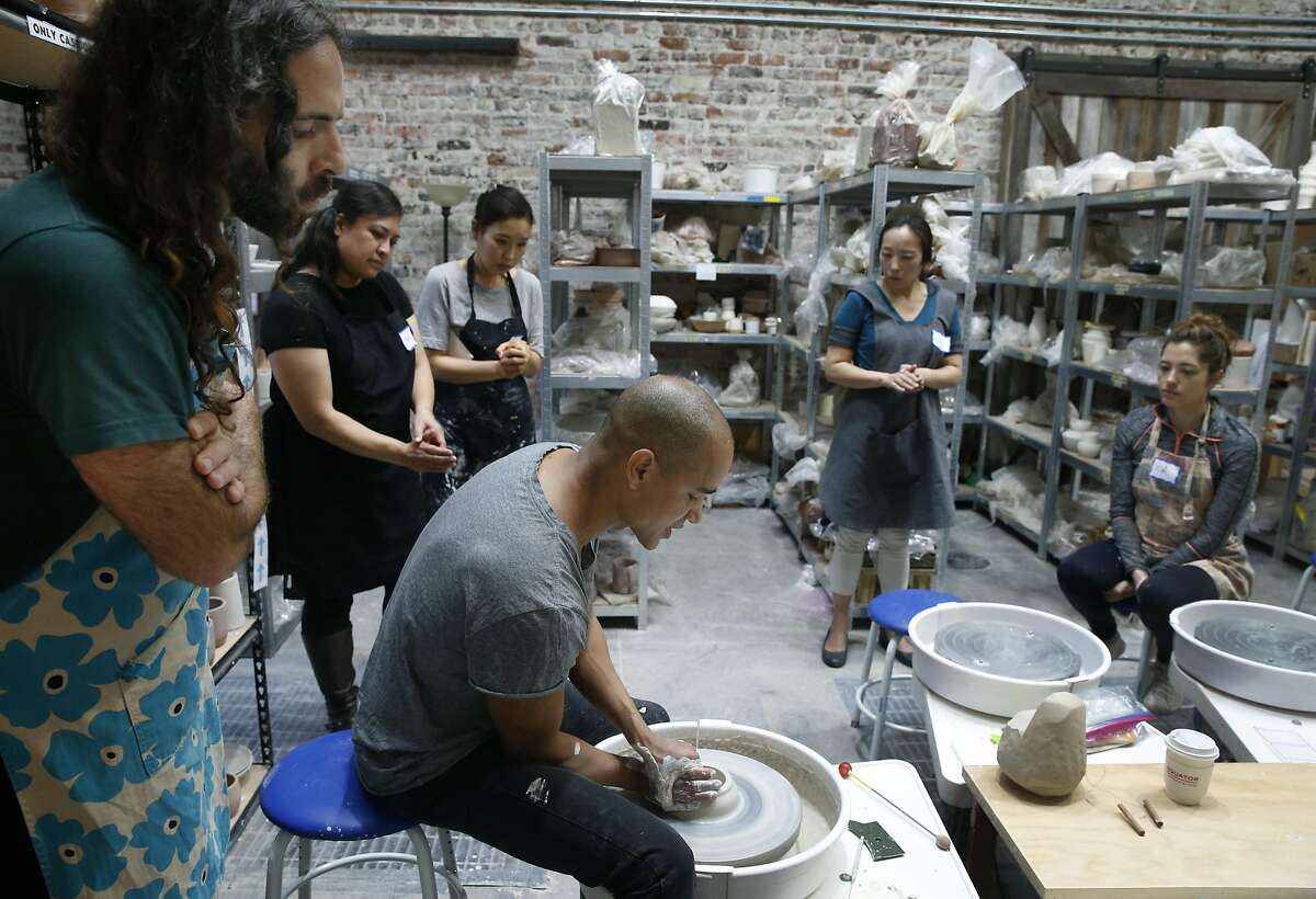 Puya Vakili (left) and other students observes master potter Eric Landon, co-founder of the Tortus Copenhagen ceramics studio in Denmark, throw clay during a two-day pottery workshop at Clay by the Bay in San Francisco, Calif. on Saturday, March 4, 2017.