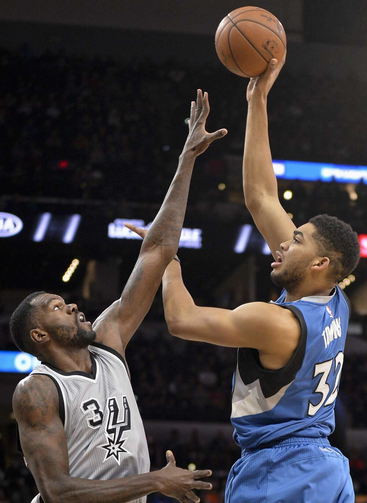 Minnesota Timberwolves center Karl Anthony-Towns, right, shoots against San Antonio Spurs center Dewayne Dedmon during the first half of an NBA basketball game, Saturday, March 4, 2017, in San Antonio. (AP Photo/Darren Abate)