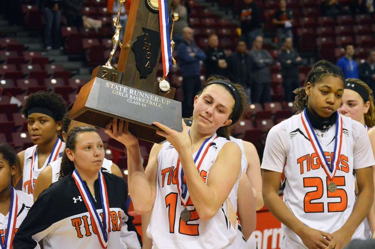 The Edwardsville Tigers accept the second-place trophy after falling to Geneva in the state championship game. Pictured from left are seniors Jasmine Bishop, Makenzie Silvey and Criste’on Waters.