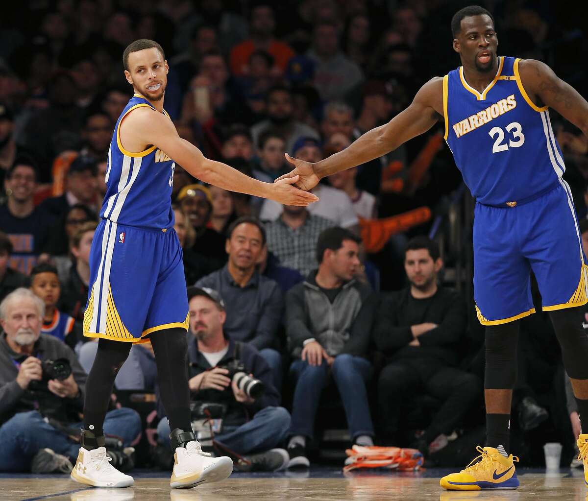 Golden State Warriors guard Stephen Curry (30) and Warriors forward Draymond Green (23) slap hands in the second half of an NBA basketball game against the New York Knicks at Madison Square Garden in New York, Sunday, March 5, 2017. The Warriors defeated the Knicks 112-105. (AP Photo/Kathy Willens)