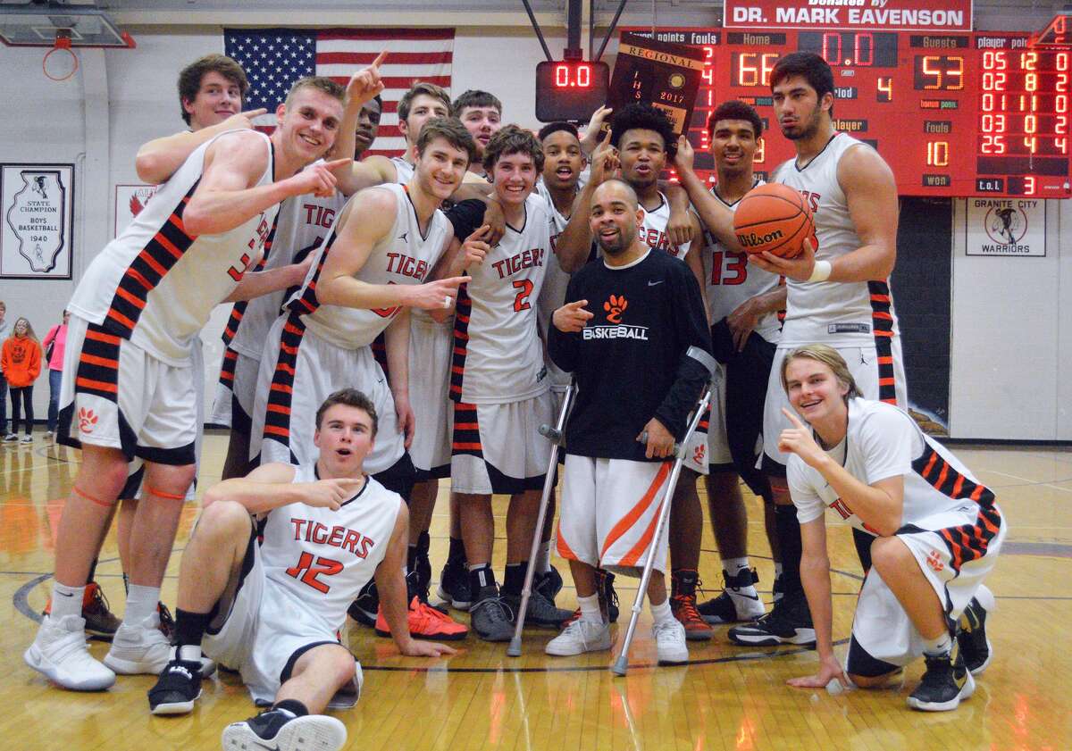 The Edwardsville boys’ basketball team poses with the Class 4A Granite City Regional championship plaque after beating Alton on Friday.