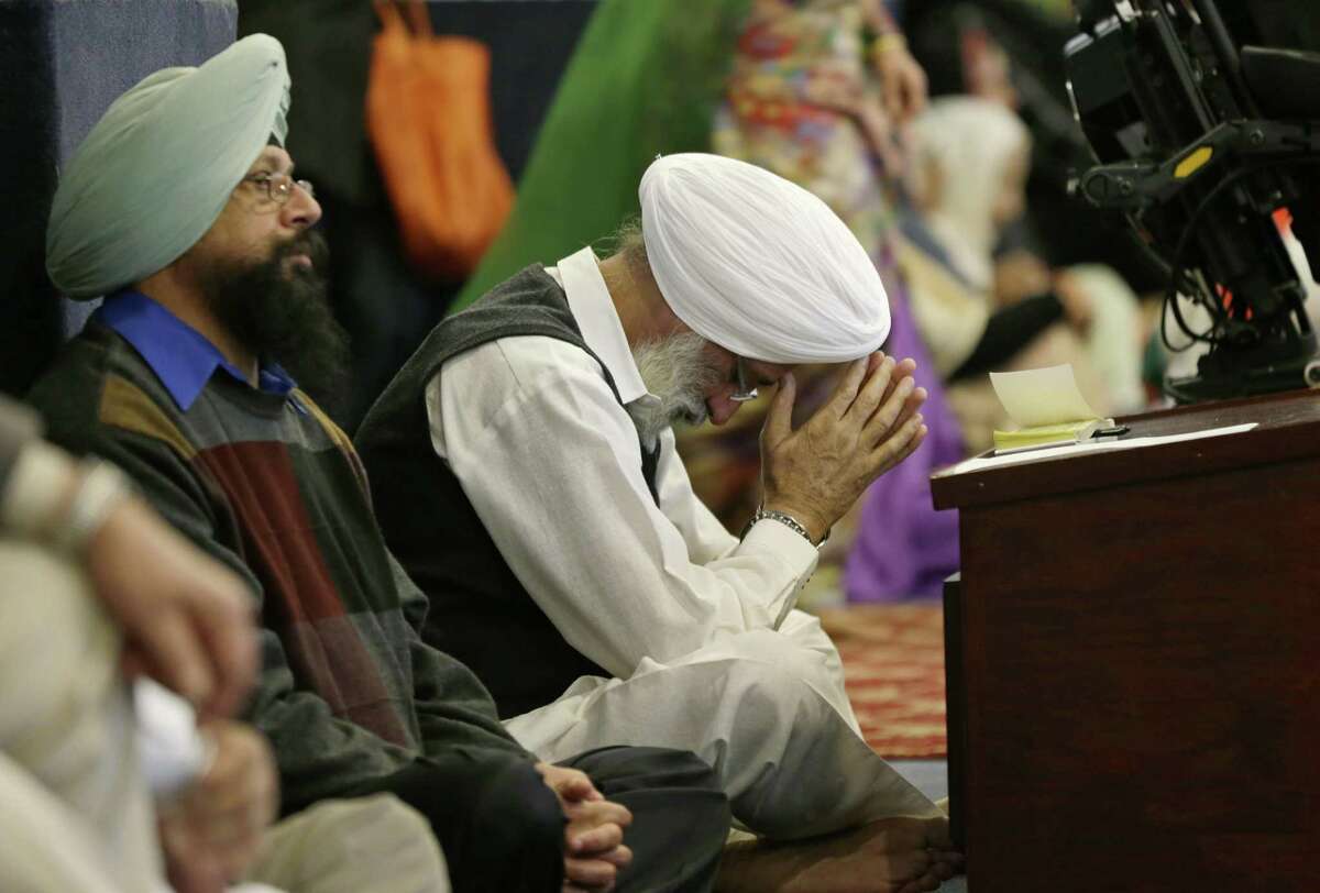 A man bows his head as he attends Sunday services at the Gurudwara Singh Sabha of Washington, a Sikh temple in Renton, Washington on Sunday in south of Seattle. Authorities said a Sikh man reported that a gunman shot him in his arm Friday as he worked on his car in his driveway and told him "go back to your own country."