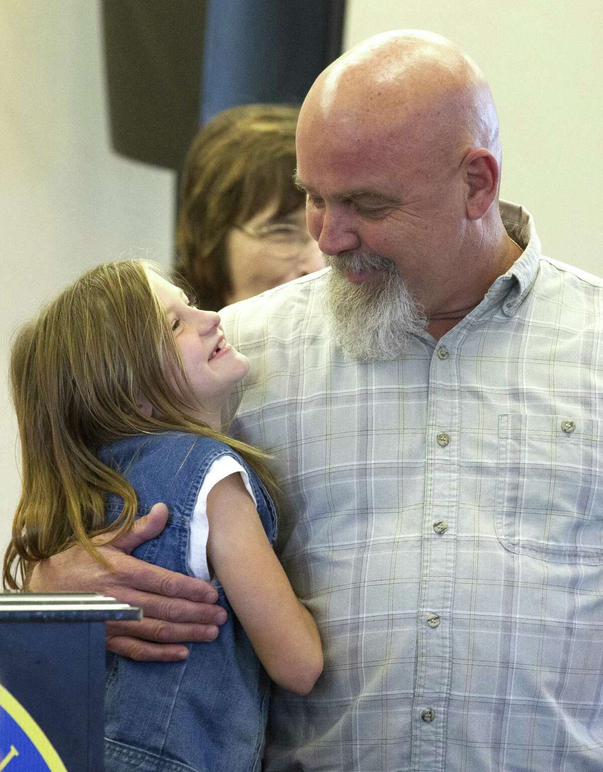 Chelsea Schmidt, a fifth grader at William Lloyd Meador Elementary School, looks up at her father Keith, whom she wrote her 'My American Hero' essay about, during a Lake Conroe Area Republican Women club meeting at April Sound Country Club Thursday, March 2, 2017, in Montgomery.