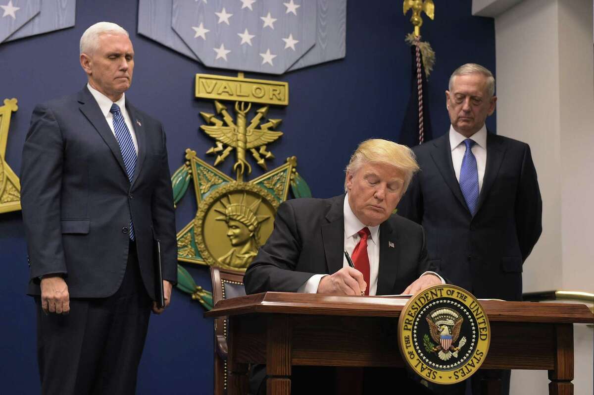 (FILES) This file photo taken on January 27, 2017 shows US President Donald Trump signing an executive order alongside US Defense Secretary James Mattis and US Vice President Muike Pence at the Pentagon in Washington, DC. Trump signed an order Friday to begin what he called a "great rebuilding" of the US armed services. The White House said on February 26, 2017, US President Donald Trump wants to hike defense spending by $54 billion, with offsetting cuts in foreign assistance and other non-military spending. Trump is expected to address budget items on February 28 during his addess to a joint session of congress. / AFP PHOTO / MANDEL NGANMANDEL NGAN/AFP/Getty Images