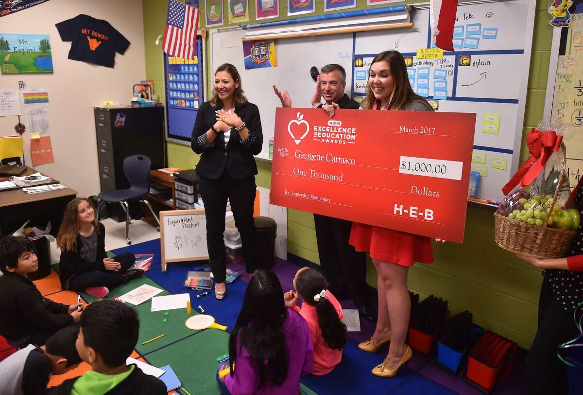 Kay Franklin Elementary School 5th Grade Special Education teacher Georgette Carrasco (left)reacts presented a $1000 check by NISD Superintendent Dr. Brian Woods and HEB's Julie Bedingfield (right) as a finalist in the HEB Excellence in Education Award.