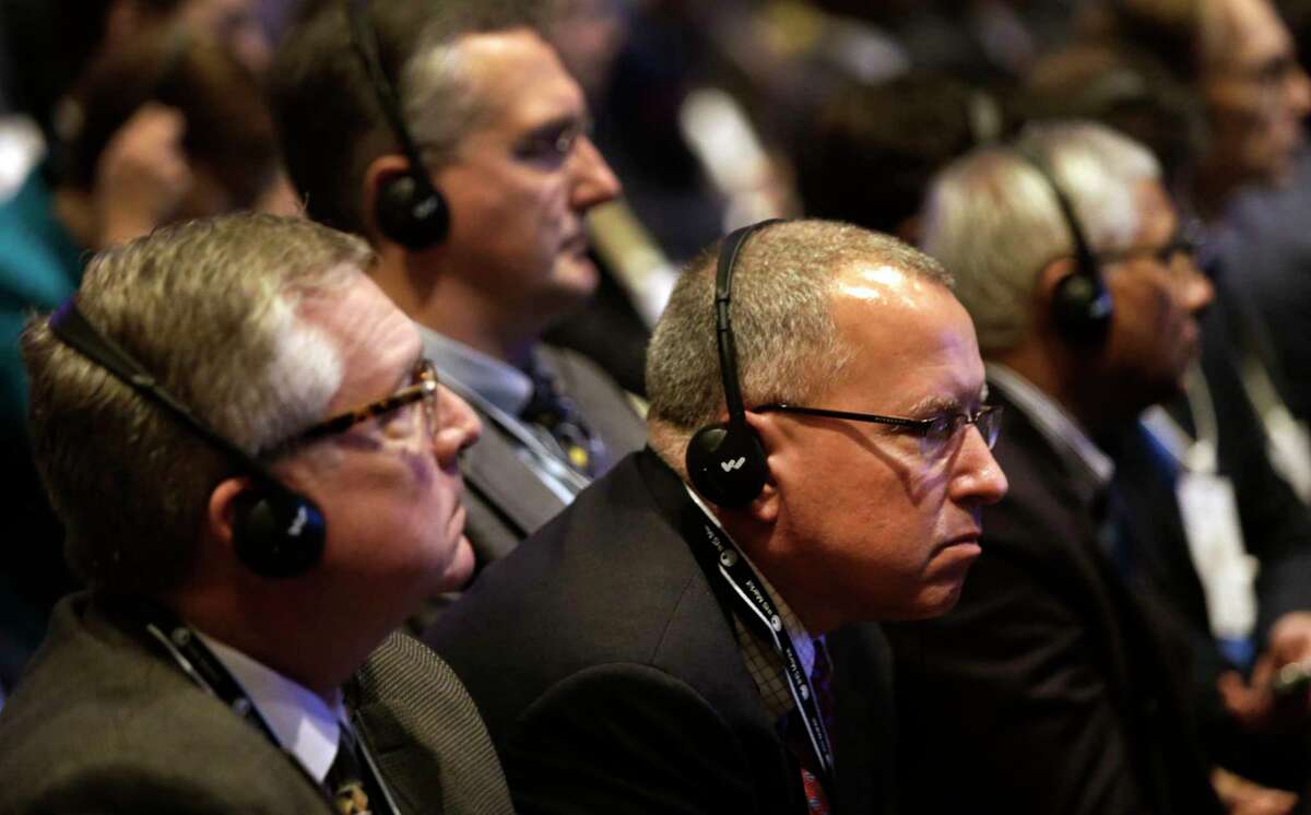 Attendees listen to translations through headsets as Alexander Novak, Russia's minister of energy, speaks Monday at the Hilton Americas-Houston.﻿