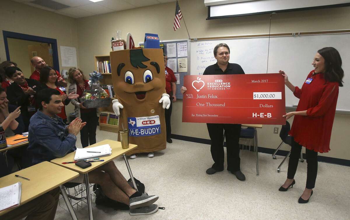 Johnson High School social studies teacher Justin Felux (center) receives a $1,000 check from H-E-B employee Lauren Olson (right) Tuesday March 7, 2017 in recognition of Felux's good work. Representatives from H-E-B are recognizing area educators as a part of their Excellence in Education Awards. Money was also donated to the school.