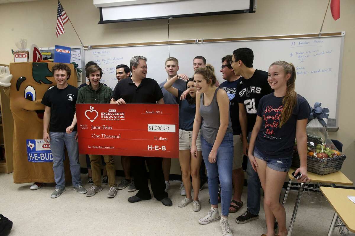 Johnson High School social studies teacher Justin Felux (center) receives a $1,000 check from H-E-B Tuesday March 7, 2017 in recognition of Felux's good work. Representatives from H-E-B are recognizing area educators as a part of their Excellence in Education Awards. Money was also donated to the school.