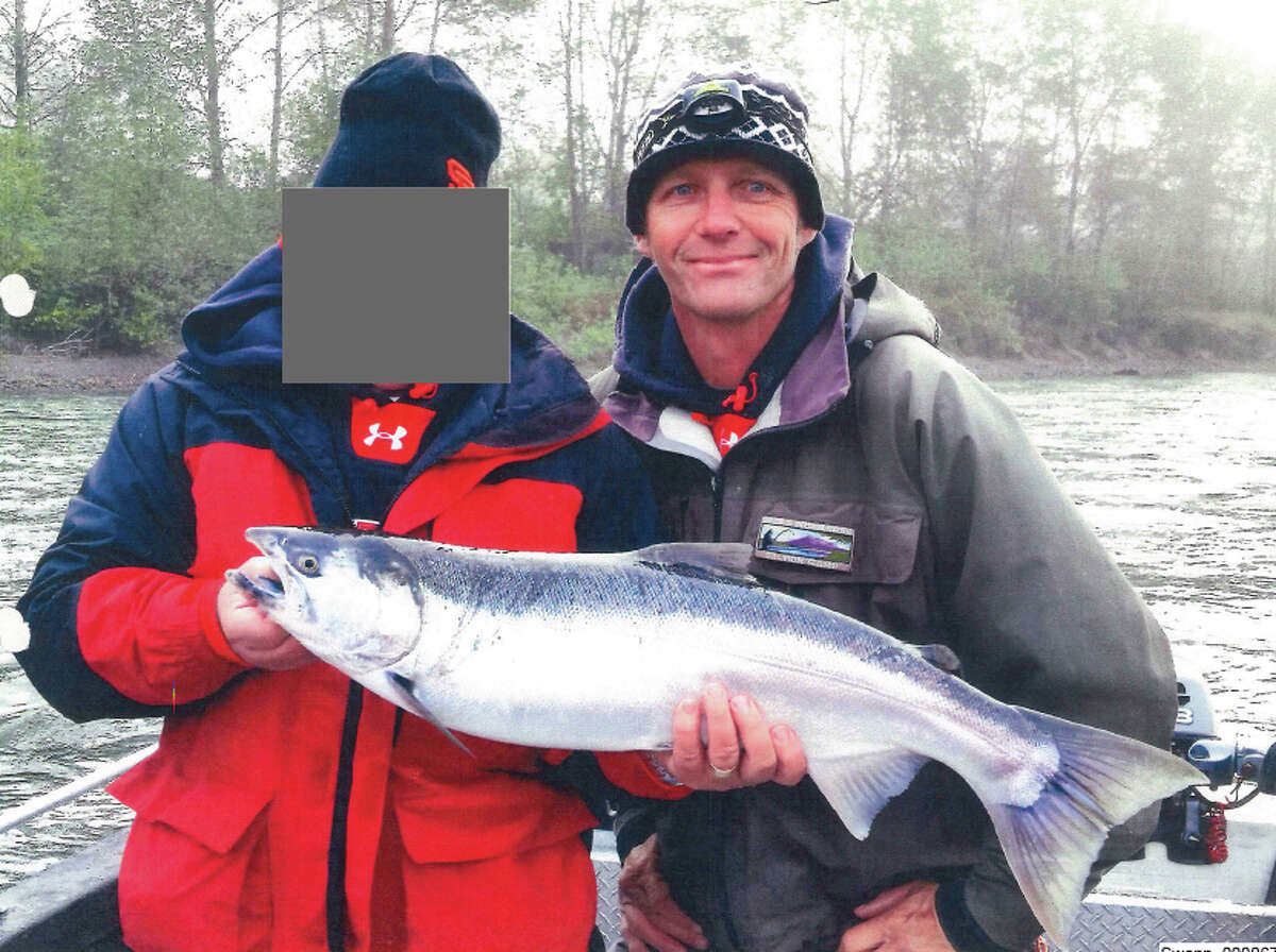 Fishing guide Bill "Swanny" Swann, pictured at right with a wild coho salmon on Washington's Cowlitz River.