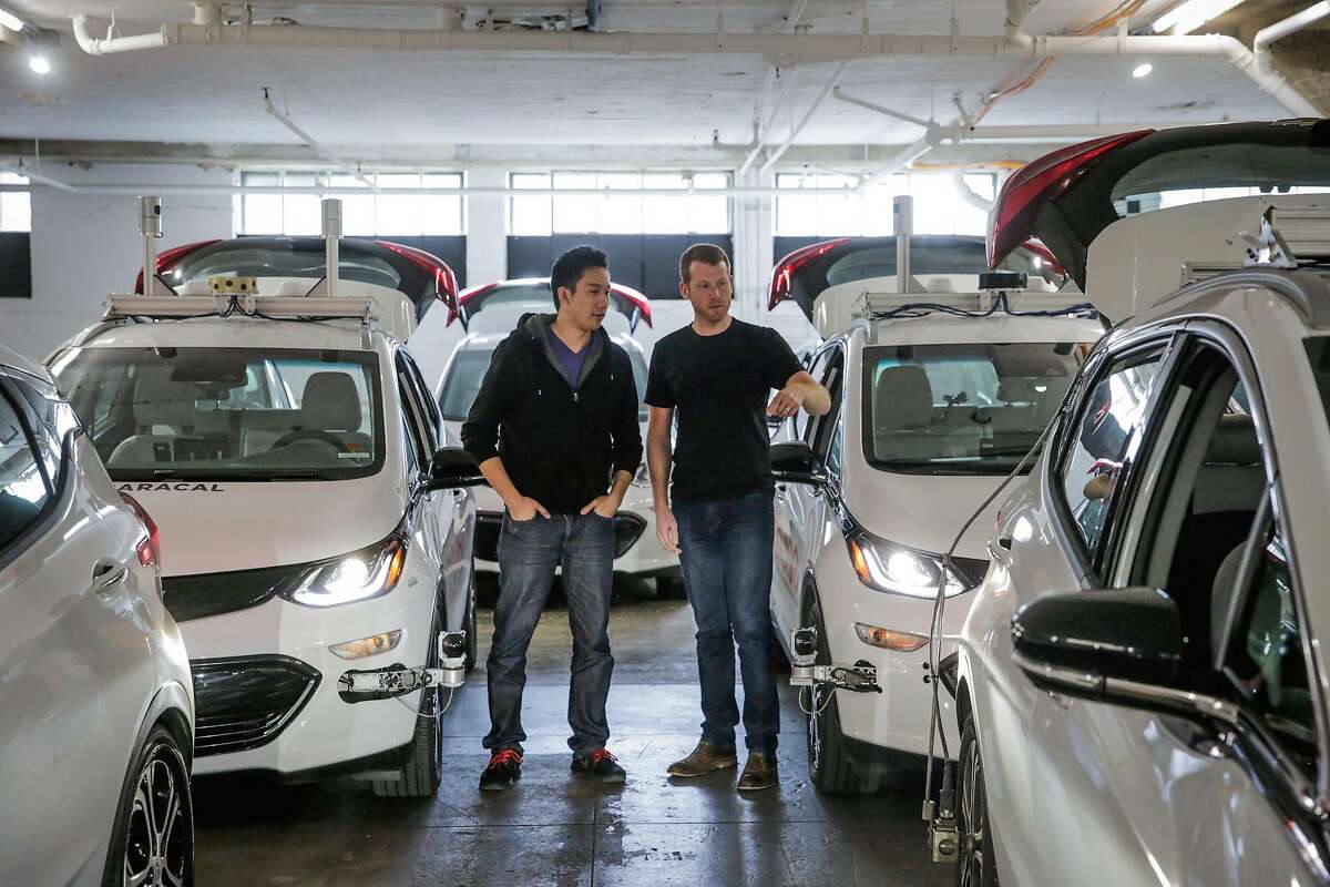 Co-founders Daniel Kan and Kyle Vogt (right) chat about a car as they stand for a portrait at Cruise Automation in San Francisco, California, on Tuesday, March 7, 2017.