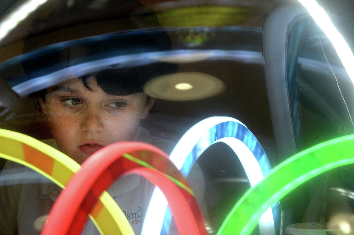 Six-year-old Winston Jepson concentrates as he tries to snag a toy prize from a carnival style game on the opening day of the Tilt Studio entertainment center in Parkdale Mall Tuesday. The 43,000 square foot facility offers a variety of colorful and interactive gaming features, including a laser tag arena, black-light miniature golf course, bumper cars, and over 100 classic and modern arcade-style games. The venue also offers party rooms for group gatherings and a snack bar. Photo taken Tuesday, March 7, 2017 Kim Brent/The Enterprise