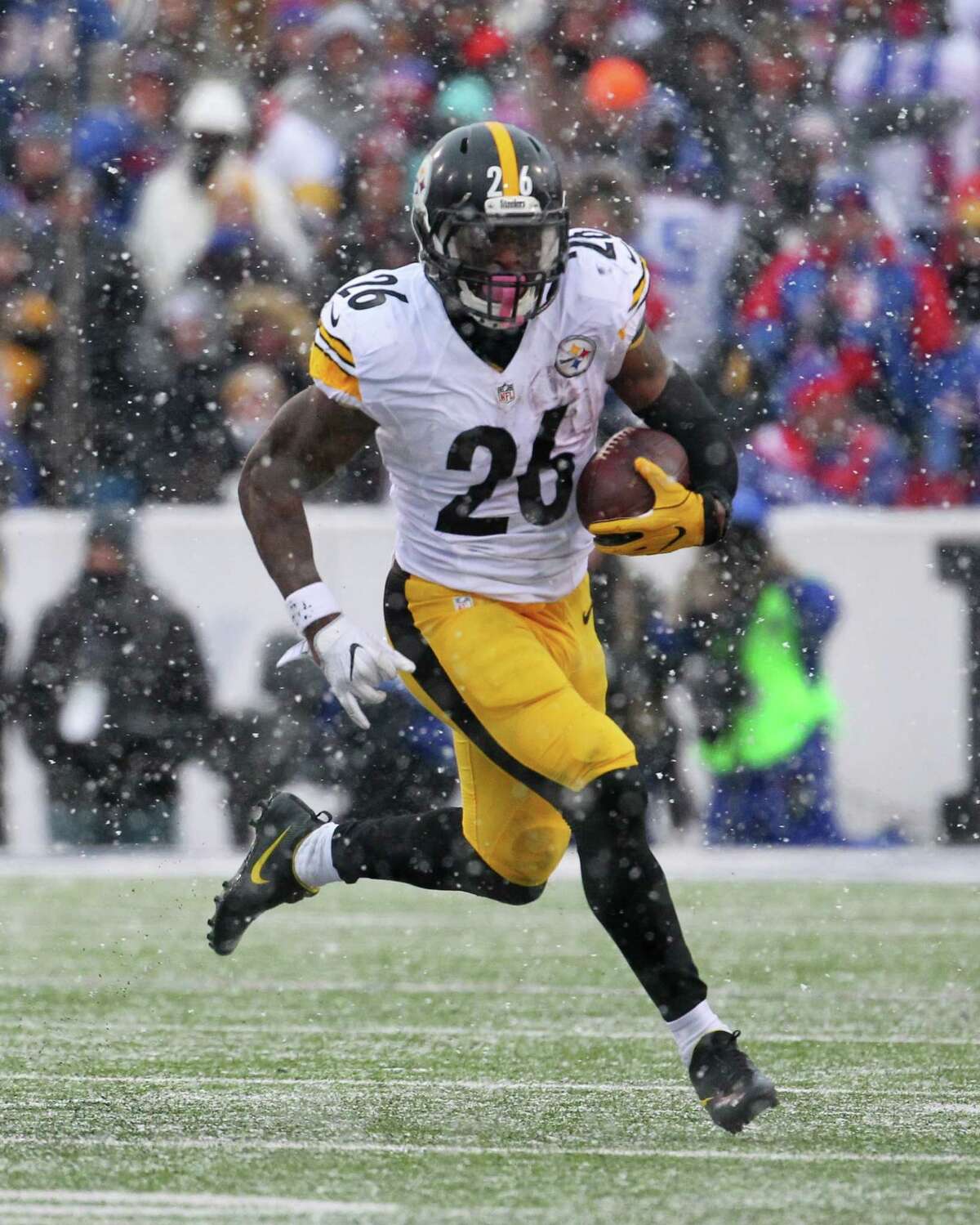 FILE - In this Dec. 11, 2016, file photo, Pittsburgh Steelers running back Le'Veon Bell (26) runs against the Buffalo Bills during the second half of an NFL football game, in Orchard Park, N.Y. NFL teams ran the ball less than ever in 2016 yet six playoff teams had a 1,000-yard rusher. Ezekiel Elliot (Cowboys), Jay Ajayi (Dolphins), Le'Veon Bell (Steelers), LeGarrette Blount (Patriots), Devonta Freeman (Falcons) and Lamar Miller (Texans) each topped 1,000 and are still playing. Last year, Adrian Peterson was the only 1,000-yard rusher in the playoffs. (AP Photo/Bill Wippert, File)