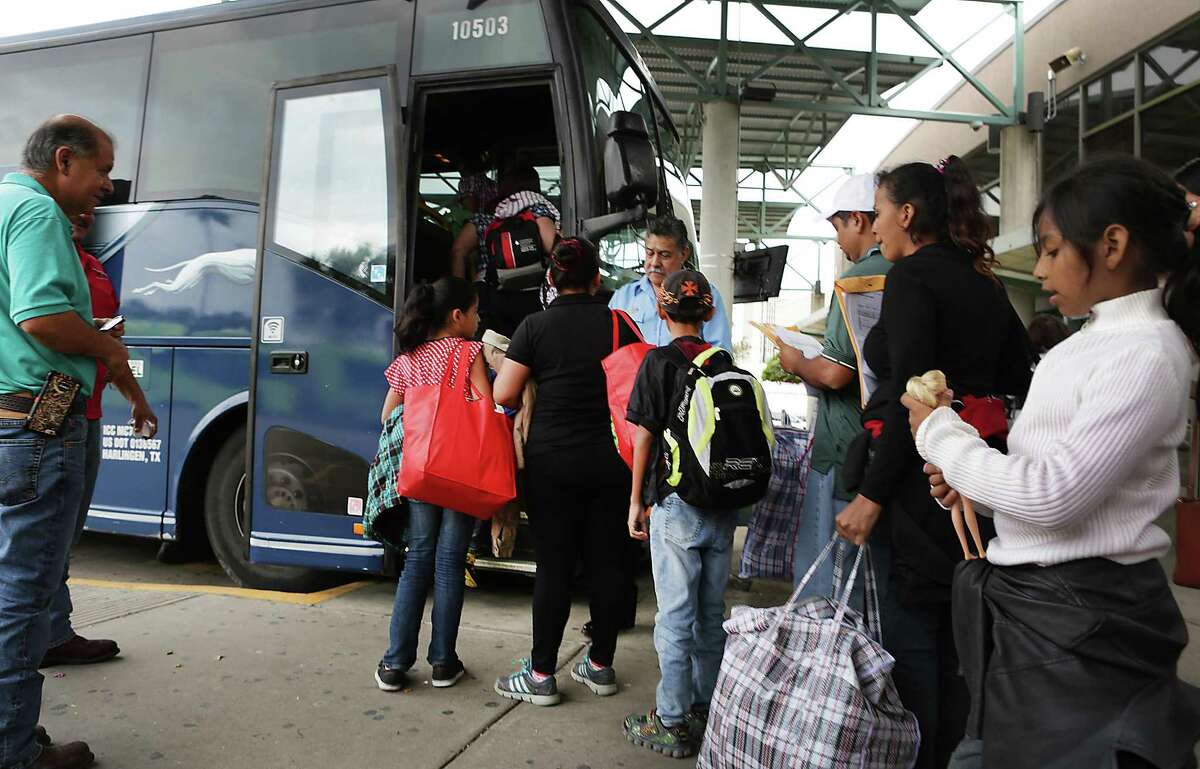 A group of immigrants from Central America is assisted by Sacred Heart Project Director Eli Fernandez, left, as they board a bus in McAllen, TX, on Tuesday, Dec. 27, 2016, traveling to join family members already in the U.S.