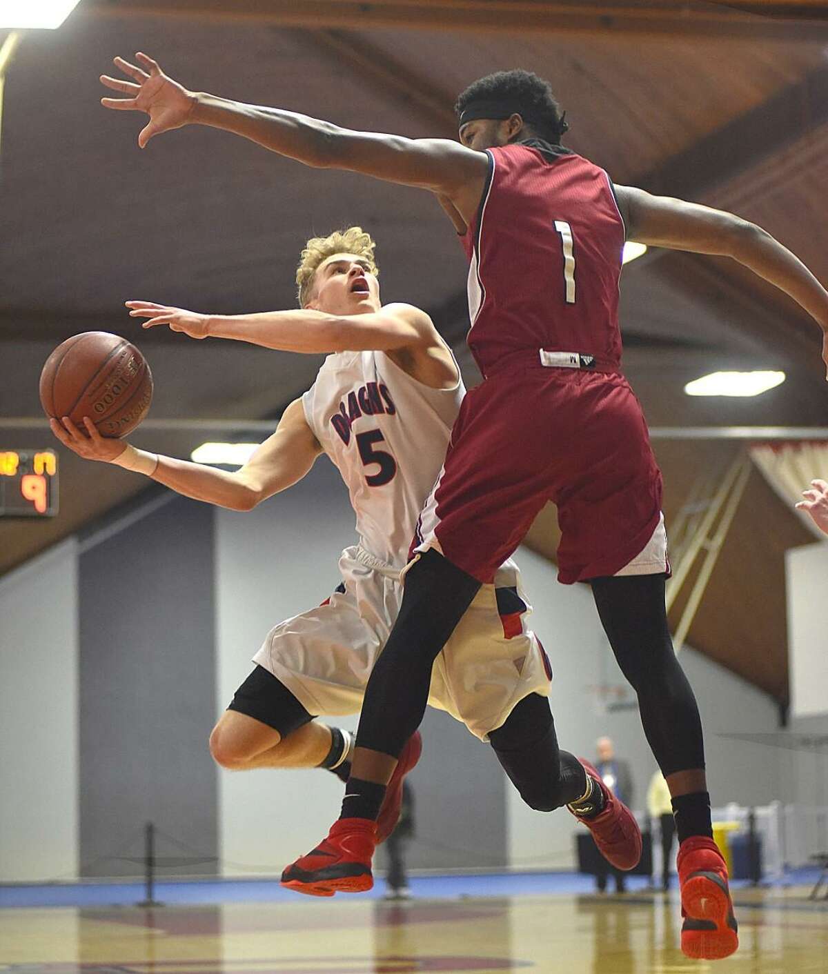 Cole Prowitt-Smith of GFA, left, puts up a shot against the defense of St. Luke’s Joel Boyce during Sunday’s NEPSAC Class C Championship game. St. Luke’s won the title with a 74-65 win.