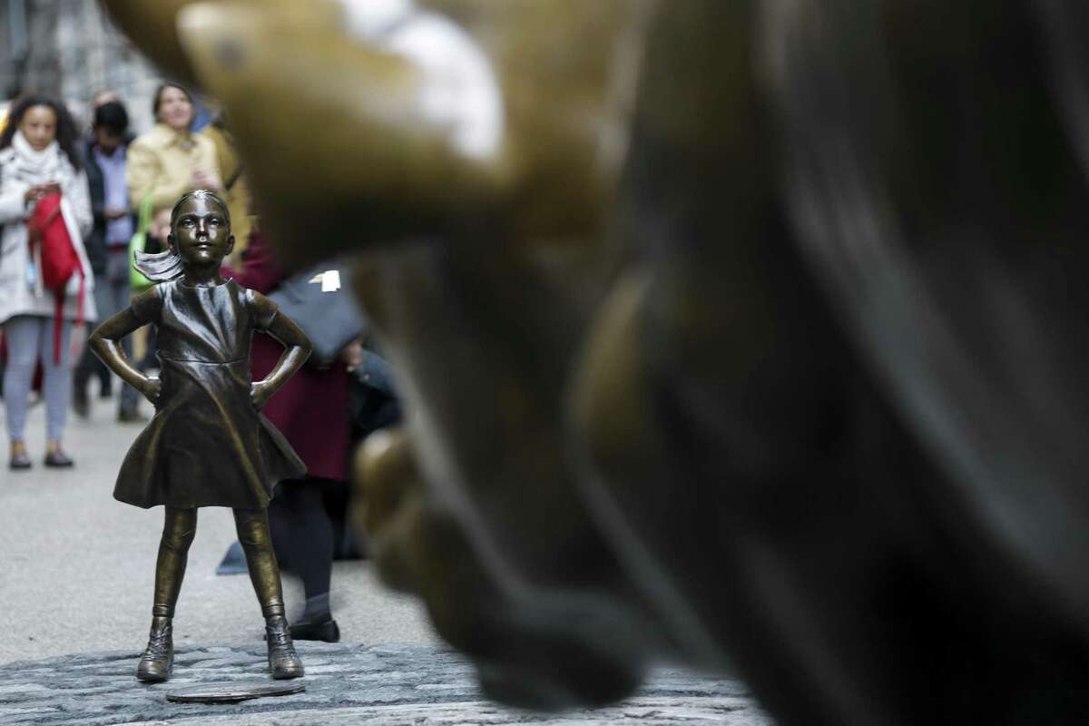 Artist Kristen Visbal’s “Fearless Girl” faces the Charging Bull sculpture. “Know the power of women in leadership. SHE makes a difference,” reads a plaque at her feet.