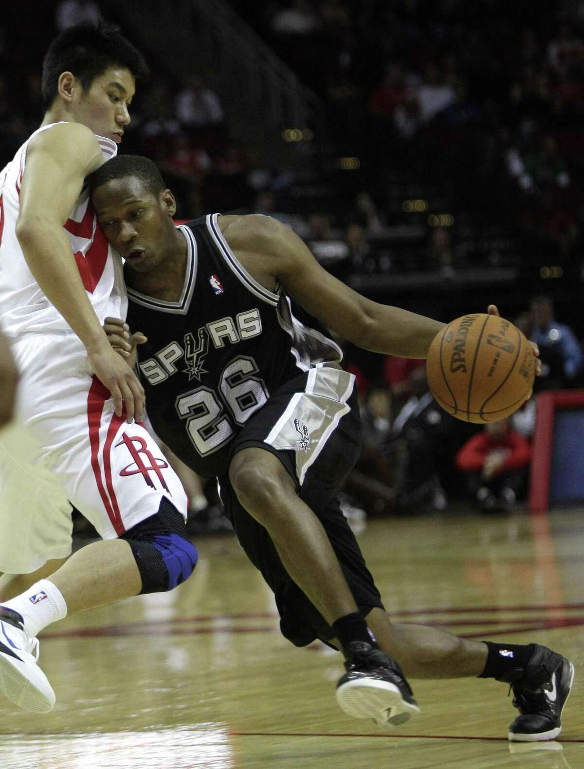 Spurs guard Antoine Hood drives with the ball against the Rockets guard Jeremy Lin during the second half of a preseason game at the Toyota Center on Dec. 17, 2011, in Houston.