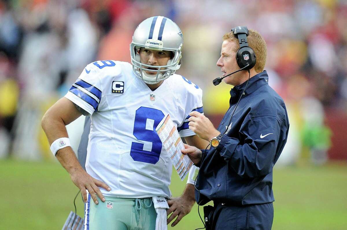 Head coach Jason Garrett of the Dallas Cowboys talks with Tony Romo during a timeout in the fourth quarter against the Washington Redskins at FedExField on Dec. 22, 2013 in Landover, Md.