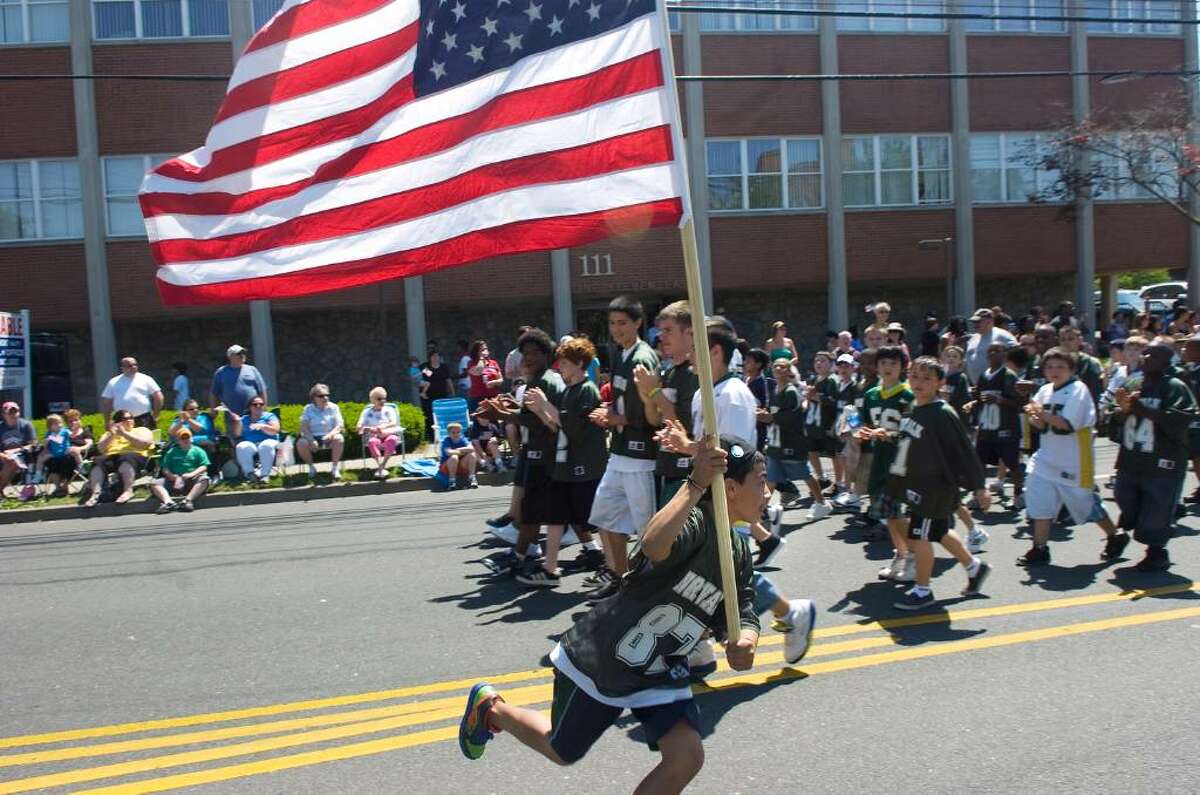 Sebastian Corren, 11, parades with the Norwalk Youth Football League during Norwalk's Memorial Day Parade from Veterans Memorial Park on Seaview Ave, along Van Zant Street and up East Avenue to the Town Green, Monday May 31, 2010.