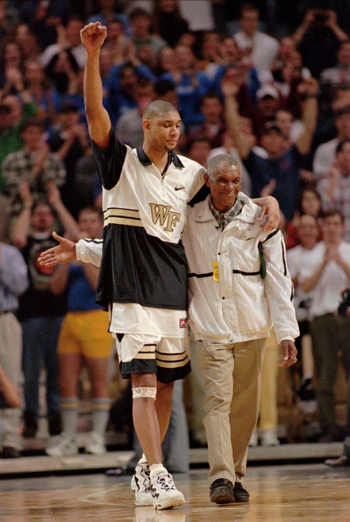 ** FILE ** Wake Forest All-American center Tim Duncan and his dad, William, are introduced to the crowd, at Joel Coliseum, in Winston-Salem, N.C., before the start of a game against Georgia Tech, in this February 25, 1997 photo. Duncan's jersey was being retired after the game. Tim Duncan will miss Game 4 of the San Antonio Spurs' playoff series Wednesday night, May 1, 2002 against the Seattle SuperSonics after his father died earlier this week. (AP Photo/Bob Jordan)
