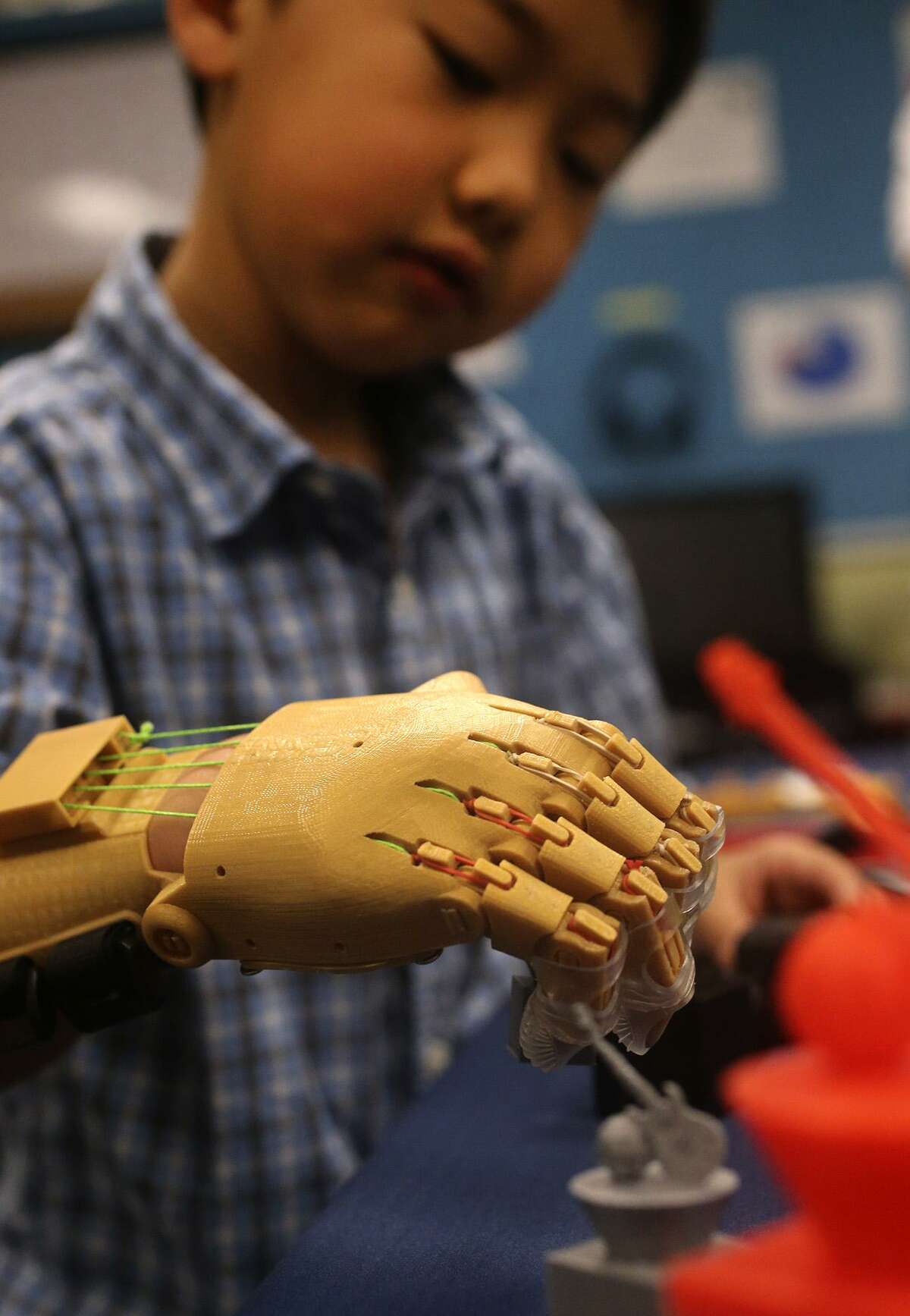 Zack Robbins,6, uses a prosthetic hand Wednesday March 8, 2017 made with a 3D printer by School of Science and Technology student Justin Cantu,16. Robbins was born with underdeveloped right hand and Cantu used technology created by an on-line community called e-NABLE to make the hand for Robbins.