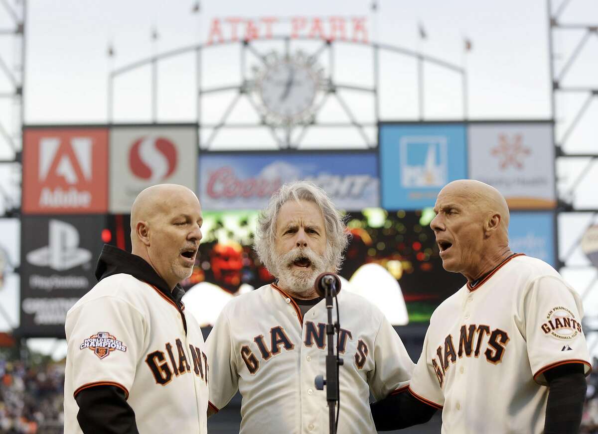 2013年8月5日，旧金山巨人队第三垒教练蒂姆·弗兰纳里(右)和他的兄弟汤姆(左)在旧金山与密尔沃基酿酒人队的棒球比赛前与感恩而死乐队的鲍勃·威尔一起唱国歌。(美联社图片/Marcio Jose Sanchez，档案)