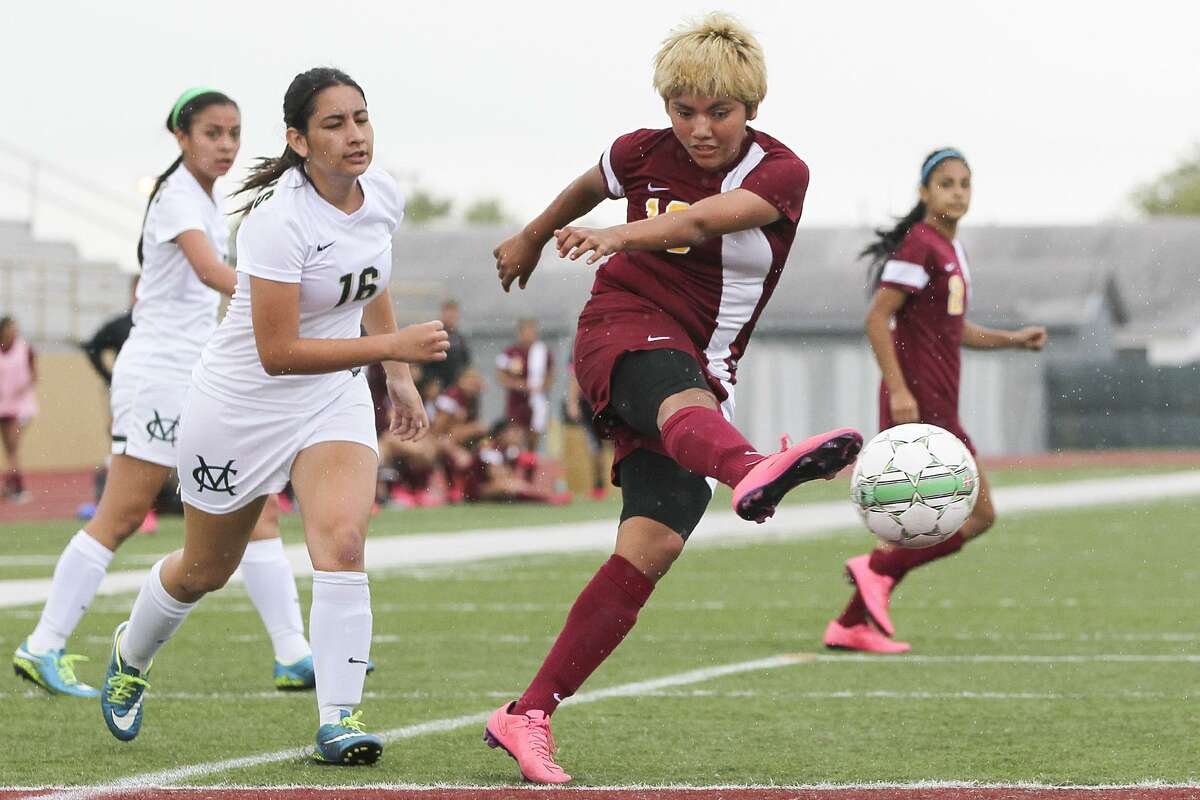 Harlandale's Jazmin Baltazar takes a shot at the goal as McCollum's Joana Villarreal (16) gives chase during their District 28-5A game at Harlandale Memorial Stadium on Thursday, March 17, 2016. Baltazar scored four goals to lead Harlandale past McCollum 6-0. MARVIN PFEIFFER/ mpfeiffer@express-news.net