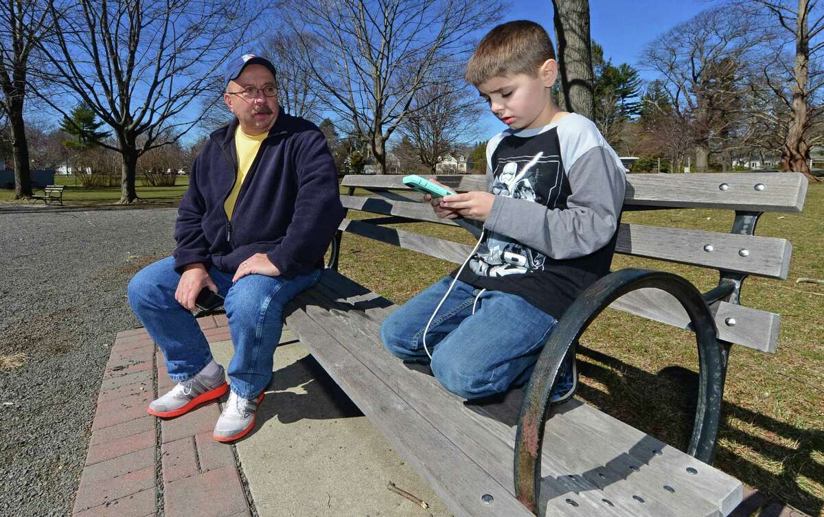 George Kufel watches his grandson, Andrew Shea, play “Pokémon Go” on Wednesday at Ballard Park in Ridgefield, Conn. While past its heyday last summer, the game has seen renewed interest after last month’s addition of 80 Pokémon and in-game events.
