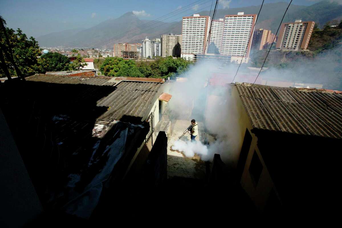 FILE - In this Monday, Feb. 1, 2016 file photo, a Sucre municipality worker fumigates for Aedes aegypti mosquitoes that transmit the Zika virus in the Petare neighborhood of Caracas, Venezuela. Ahead of the annual American College of Cardiology conference in Washington in March 2017, doctors say they have tied infection with the Zika virus to possible new heart problems in adults. The evidence is only in eight people in Venezuela and does not prove a link. It's too soon to know how often this might be happening, although it seems less common than the troubles the mosquito-borne virus has been causing for pregnant women and their fetuses. (AP Photo/Fernando Llano)